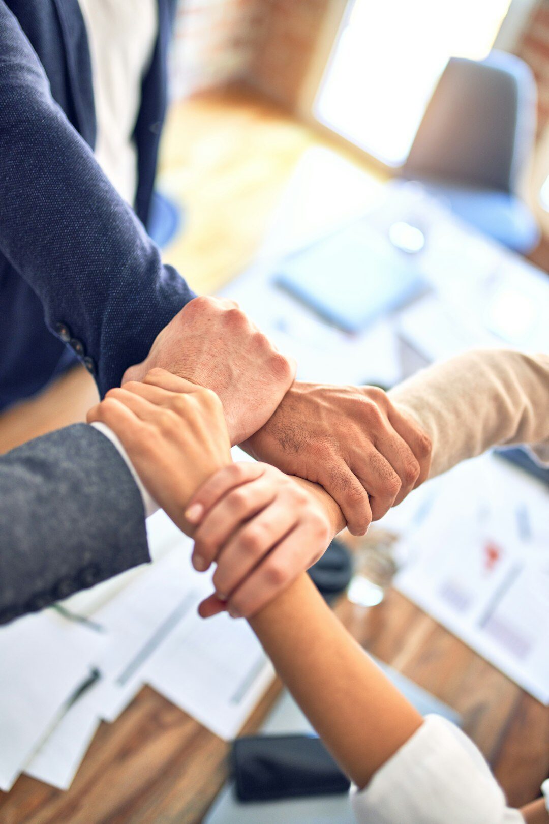 Close up of colleagues stacking hands together in a team huddle